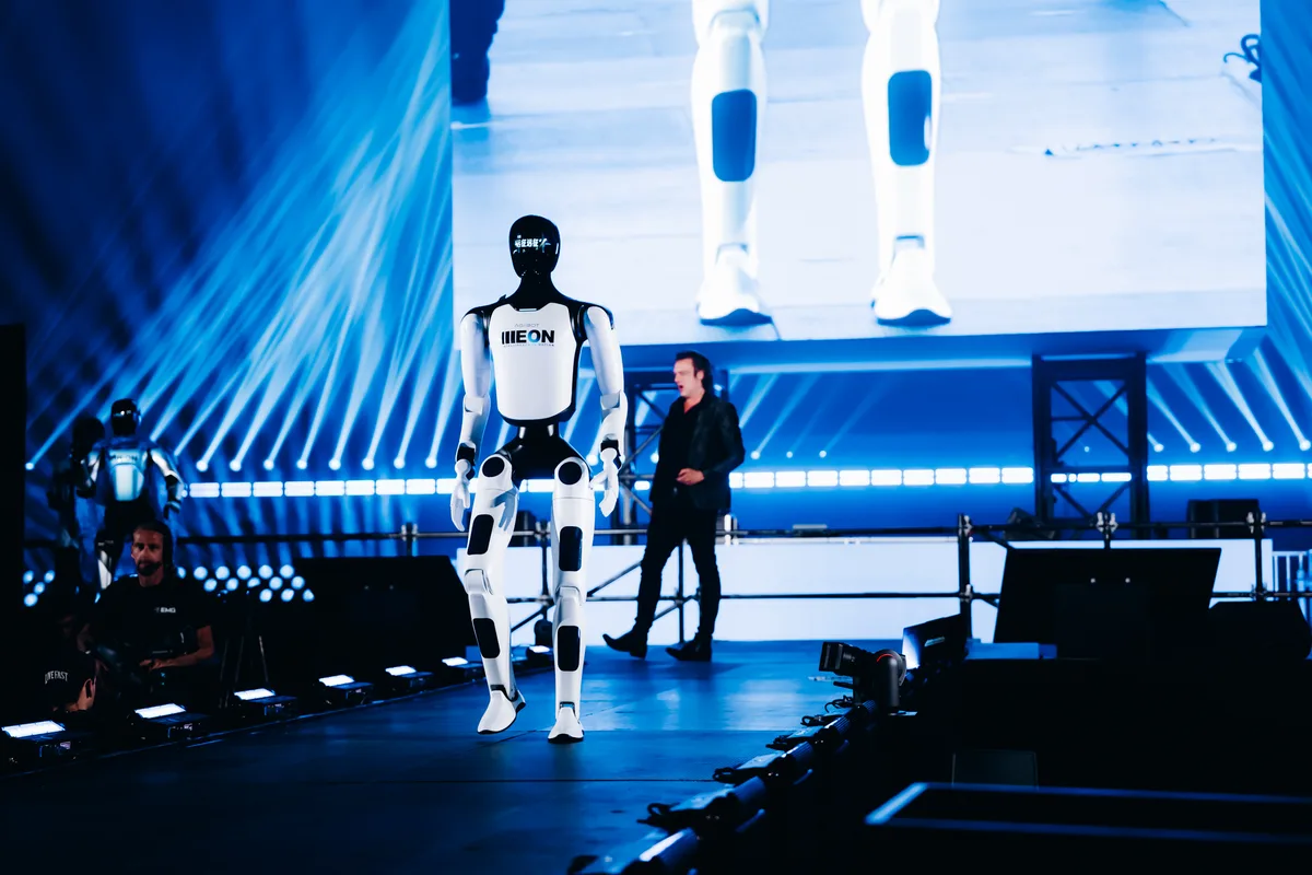 AGIBOT A3 robot walking across the stage with a presenter at the LoveTomorrow event